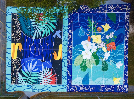 Overhead rendering of a basketball court with white lines showing court markings. The court itself is unexpectedly botanical and covered in various shades of blue, with flowers blooming near center court.