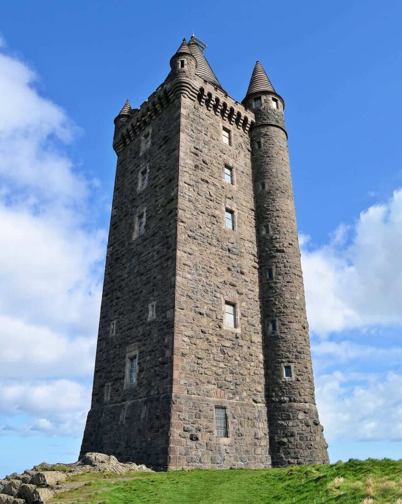 A stone castle on a hill with a blue sky background