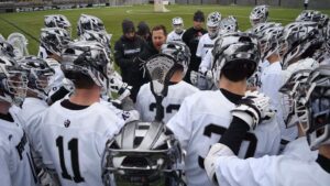 Coach G gives his team a speech in the huddle before a game.