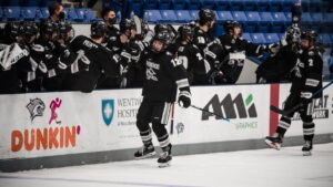 Nick Poisson celebrates with team after scoring goal.