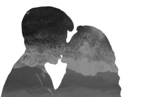 A woman and a man kissing with the ocean filling up their outlines