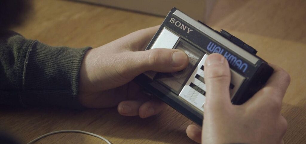 A person listening to and looking at his Walkman 