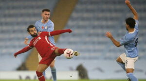 Liverpool forward Mohamed Salah holds off Manchester City defender Aymeric Laporte in a 1-1 draw this past weekend.