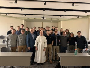 Father Shanley and A.D. Bob Driscoll pose with the sports business organization