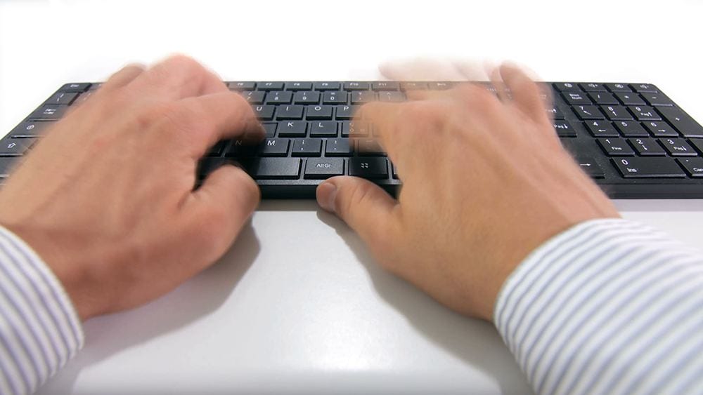 A person typing on a keyboard