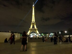 People dancing in front of the Eiffel Tower at night 