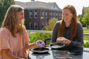 Two girls enjoying Allie's Donuts outside Eaton Street Cafe.