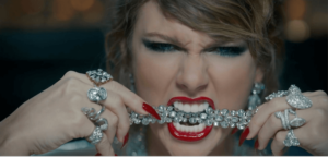 A still from Taylor Swift with jewelry in her mouth from her new music video for her song "Look What You Made Me Do." 