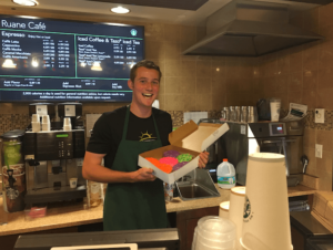 Student holding box of donuts at Ruane Cafe.