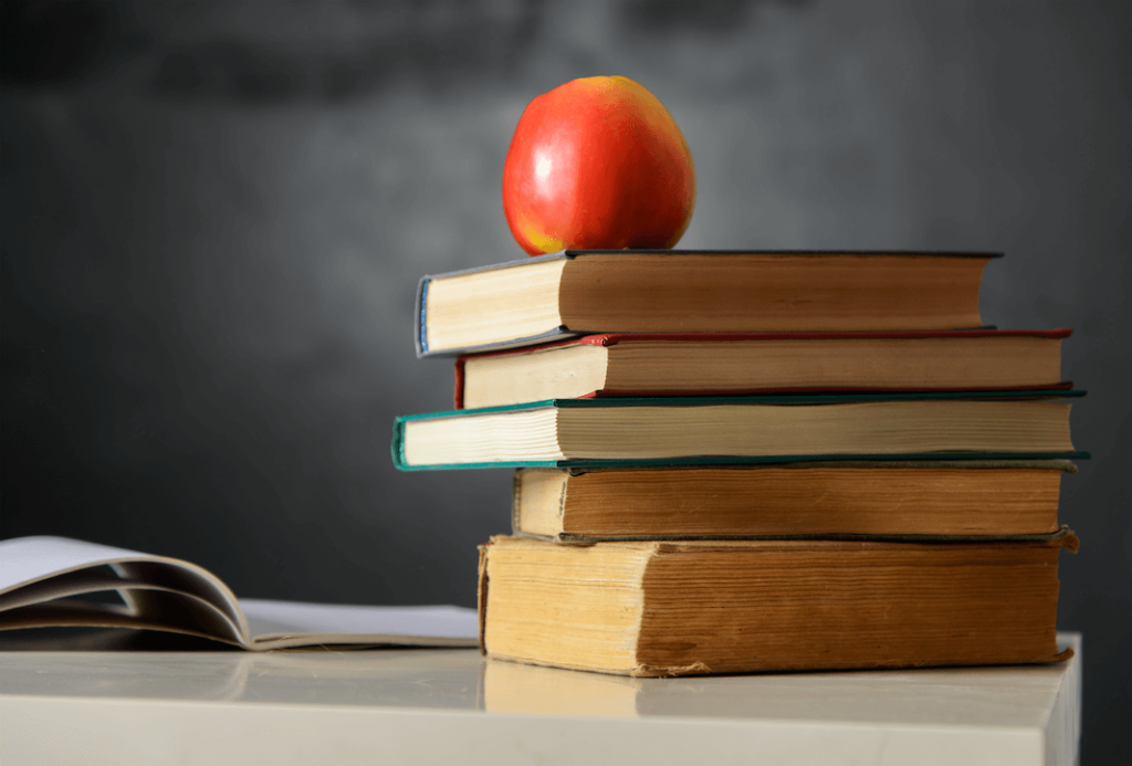 Stack of books with an apple on top.