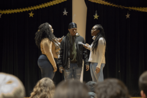 Phionna Cayola Claude ’18 (left), Kingsley Metelus ’21 (middle), and Sara Jean-Francois ’19 preform their poem on stage.