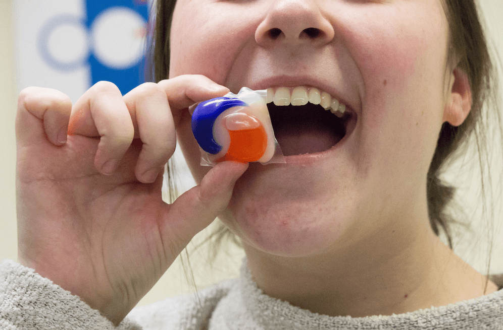 A student holding a tide pod near their mouth.