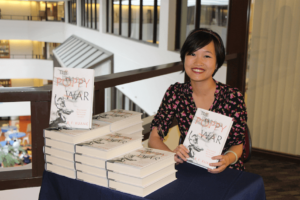 Rebecca Huang (above) posing with a copy of her novel, The Poppy War.