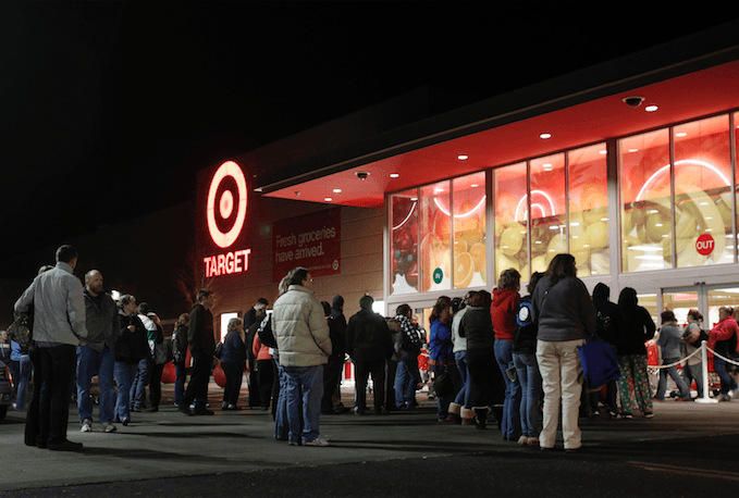 Photo of a long line of people standing outside Target at night.