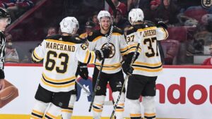 boston bruins players brad marchand, patrice bergeron, and david pastrnak celebrate a goal in montreal