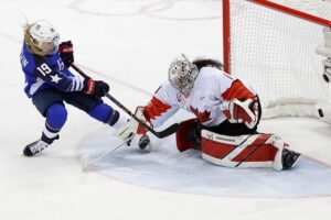A member of the USA womens hockey team shoots on Canadian goalie during the gold medal game in the olympics.