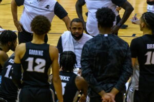 Ed Cooley speaks to his team during a huddle.