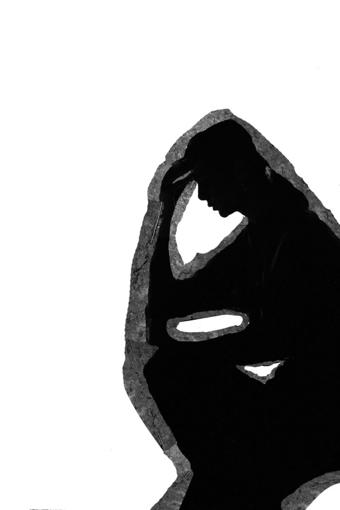 Silhouette of woman holding her head
