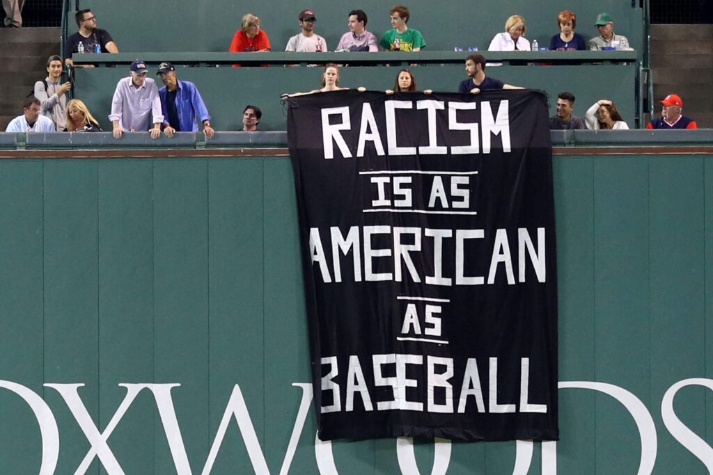 Protestors display their anti-racism banner in Fenway Park last Wednesday, Sept. 13. The banner reads: "Racism is as American as baseball."
