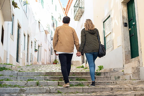 A couple walking up stairs on a street