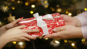 two people exchange a Christmas present