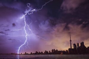 Lightning striking off the coast of a city 