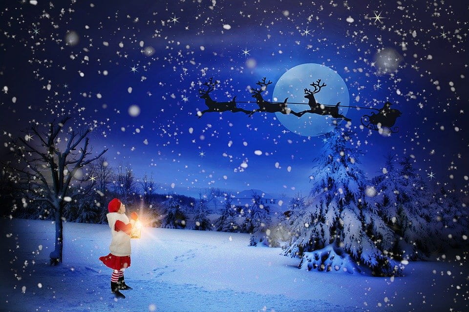Girl staring up at Santa riding in the wintery night sky on his sleigh 