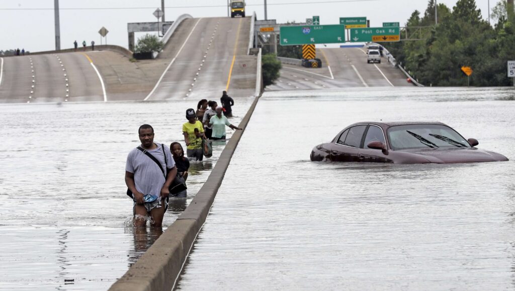 A group of citizens walking through a flooded interstate in Texas during Hurricane Harvey.