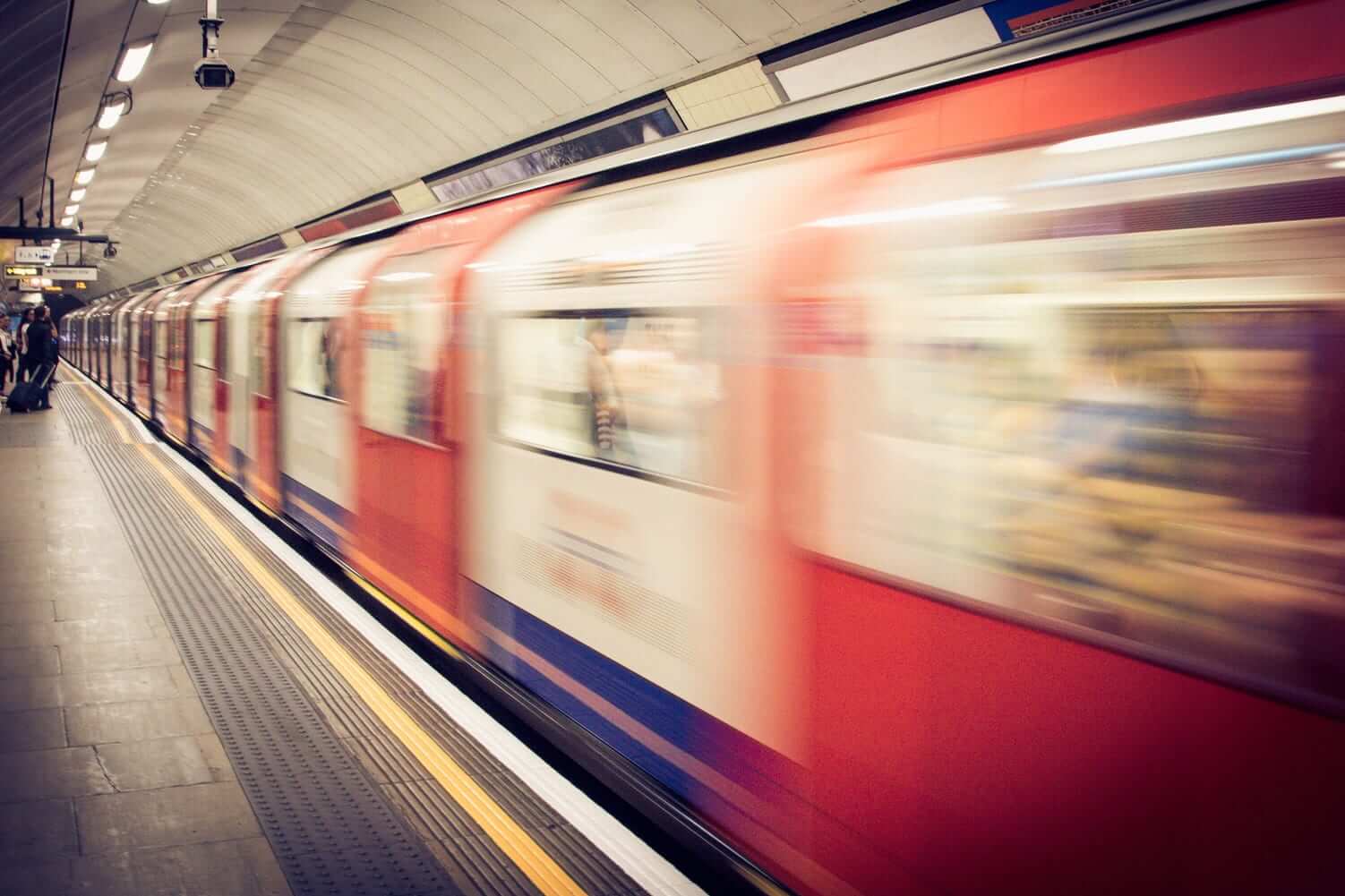 Subway passing people by as it leaves the station