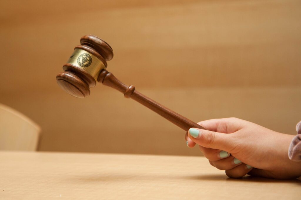 A hand holding a gavel over a table.