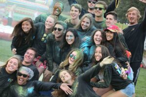 A photo of Board of Programmers members smiling and covered in colored powder
