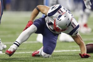 Edelman grips his leg as he falls to the ground.