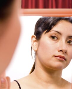 Girl Looking At Herself In The Mirror And Checking Her Makeup