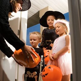 Women giving candy to kids trick or treating 