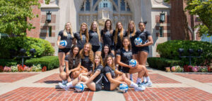 Women's Volleyball poses in front of Harkin's Hall